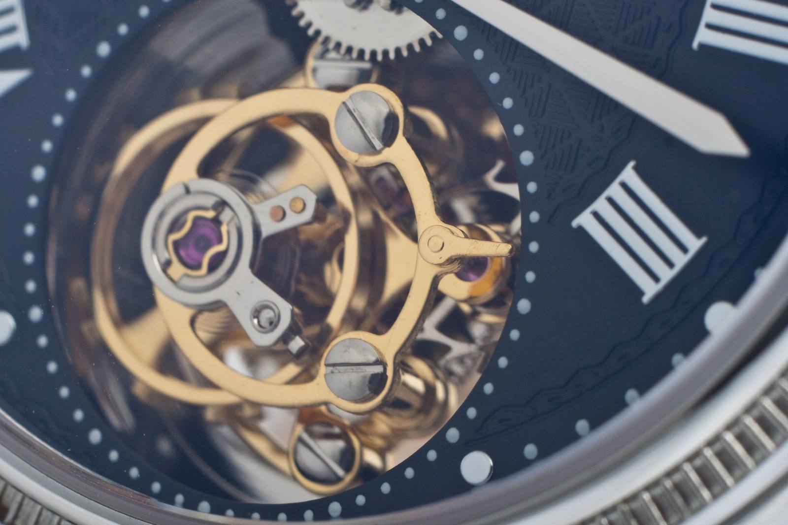 Close-up of a tourbillon wheel in a mechanical watch movement.