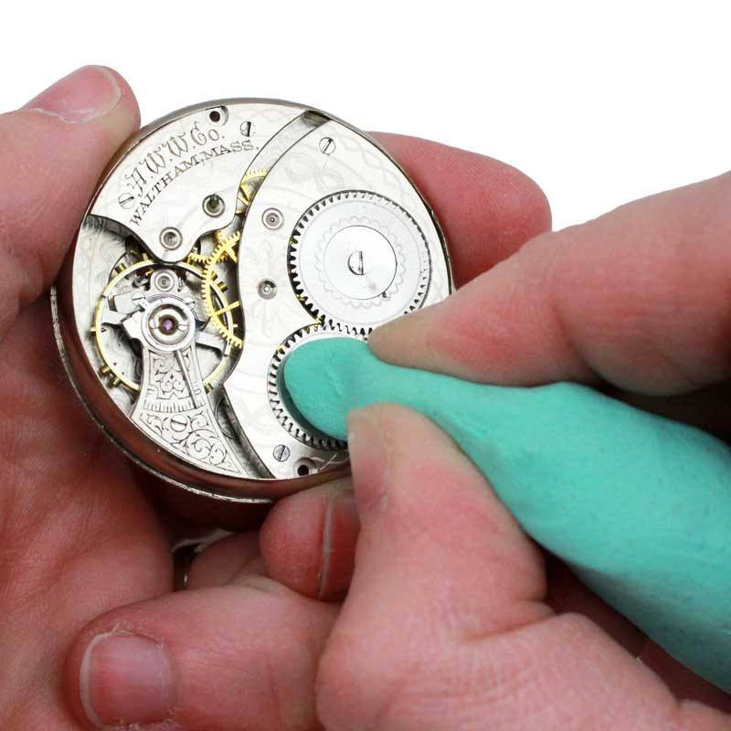 Green Rodico putty cleaning a vintage pocket watch movement