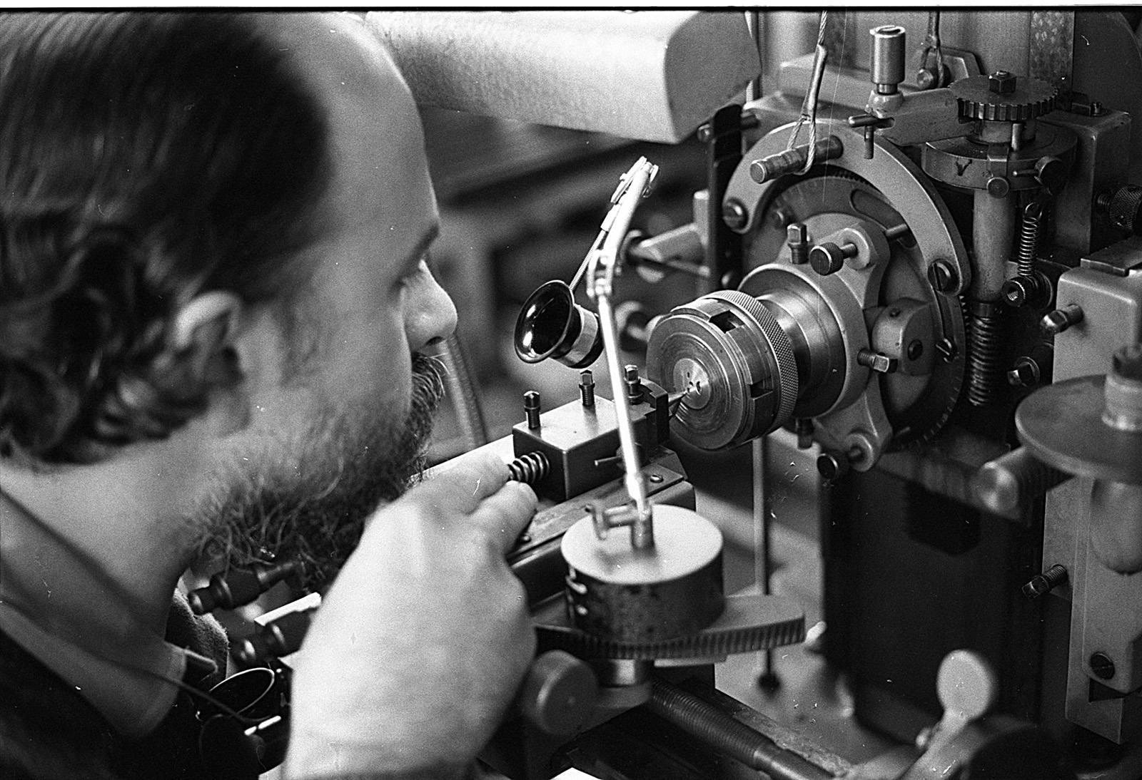 Derek Pratt at work on his engine-turning machine, guiding the cutter as it traces a guilloche pattern into a dial plate.