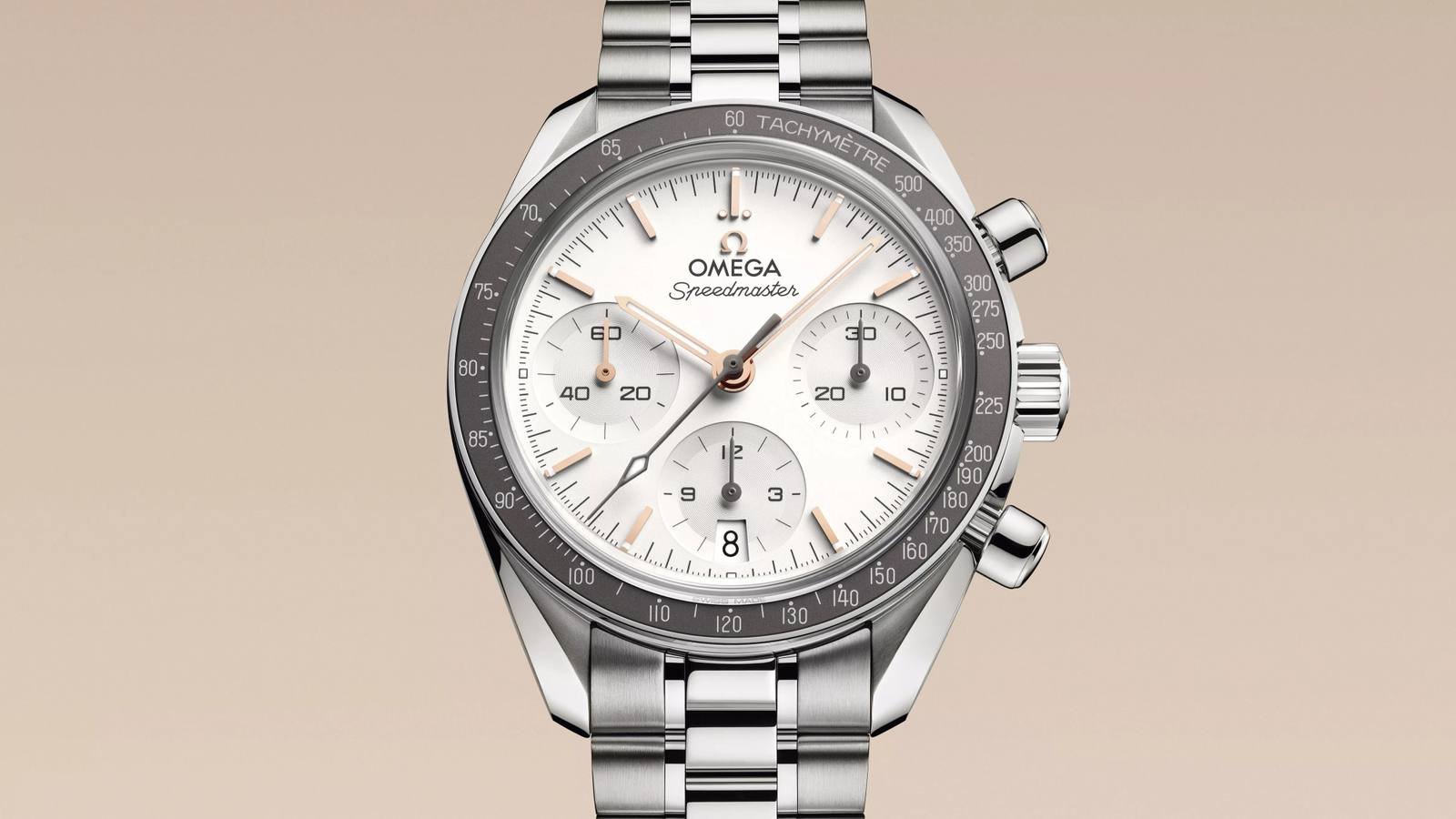 Omega Speedmaster 38 chronograph with silver opaline dial, Sedna gold hands and warm grey tachymeter bezel.