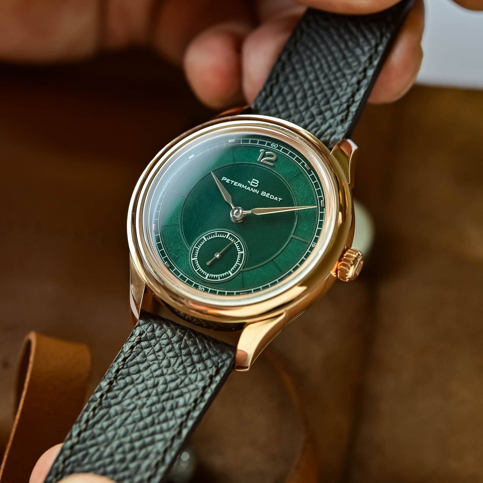 Close-up of the rose-gold Petermann Bedat Reference 1825 green enamel dial held in hand