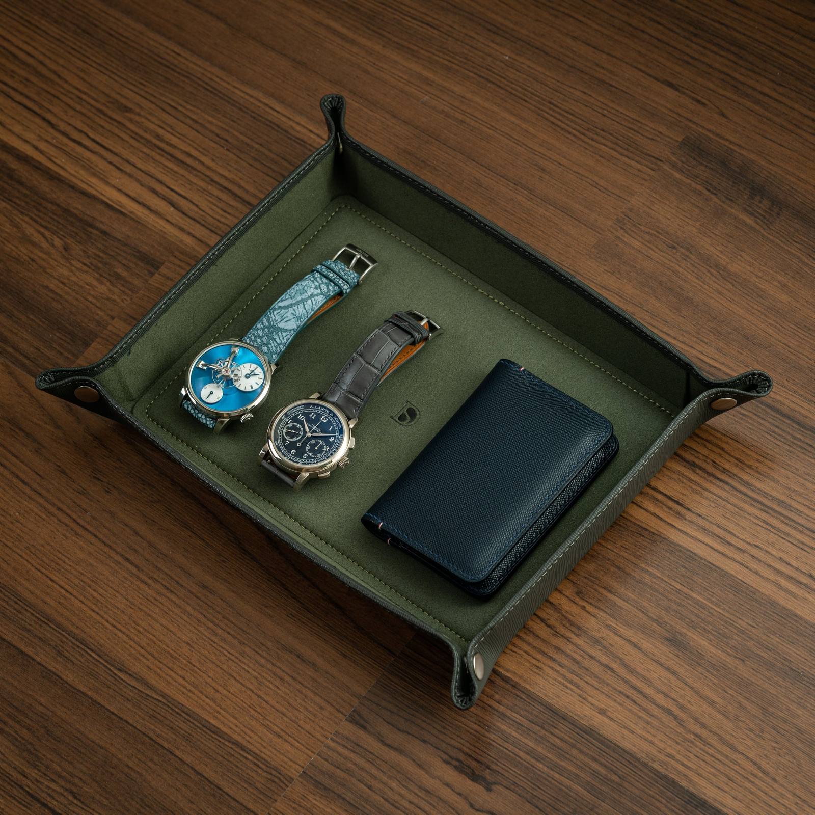 Delugs valet tray in grey with dark green interior holding two wristwatches and a card wallet